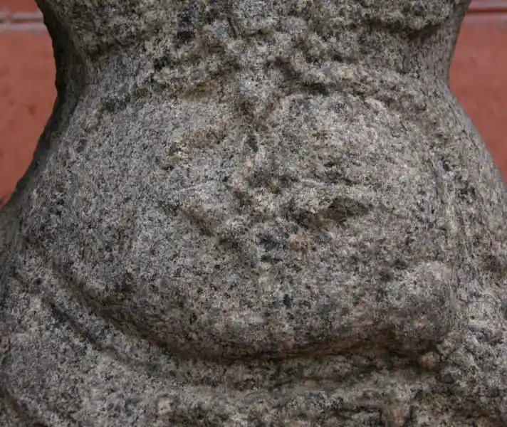 Four-pointed flower-like belly button on an Indian statue